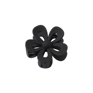 Macro view of matte black floral hair claw clip with cutout five-petal flower design
