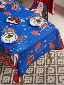 Detailed close-up of blue Christmas tablecloth with Santa, reindeer and snowflake patterns