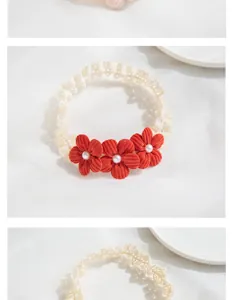 Detail of red fabric flowers with pearls on soft elastic lace headband for babies