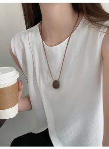Chic brown stone pendant on a slim wax cord necklace worn by a model in casual attire