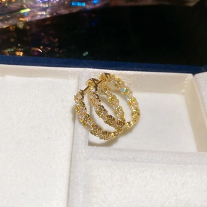Gros plan de boucles d'oreilles dorées en zircon et nacre dans un coffret à bijoux blanc