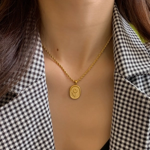 Vintage gold oval sunflower pendant necklace with twisted rope chain on houndstooth suit