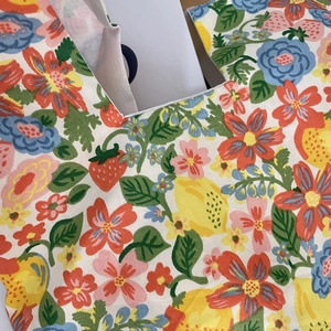 Close-up of floral cotton canvas wrist bag with strawberry and lemon print patterns