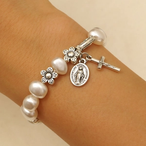 Detail of baroque pearl bracelet with Virgin Mary medal and silver cross charm