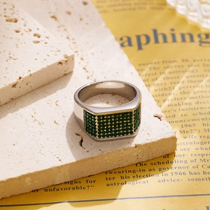 Detail view of silver titanium steel ring with rows of inlaid green zircon stones