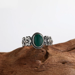 Vintage S925 silver ring with oval green malachite and floral design on wood