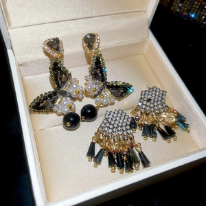 Detail shot of butterfly pendant earrings with black crystals and dark fringe tassels