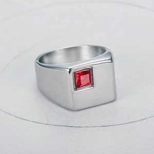 Macro di un anello in acciaio al titanio argento con gemma rossa a taglio quadrato incastonata