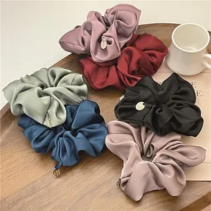 Elegant set of six satin scrunchies in various colors with small gold metal pendants