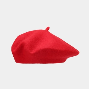 Detailed close-up of high-quality red wool beret showing soft fabric texture and stem