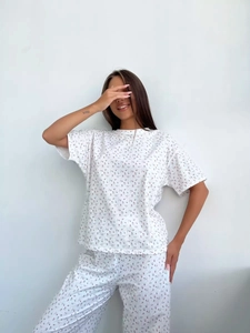 Detail of soft cotton pajama set featuring delicate red floral print and short sleeves