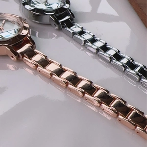 Detail of rose gold and silver quartz watches with elegant metallic link straps