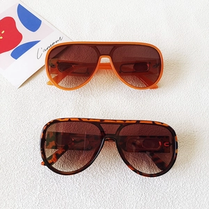 Oversized aviator sunglasses in orange and tortoise shell frames on a white background