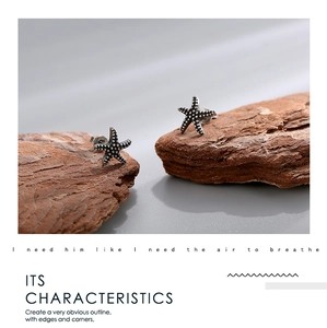 Macro shot of vintage silver starfish stud earrings with detailed granular texture