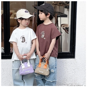 Street style view of kids wearing trendy mini handbags and casual summer outfits
