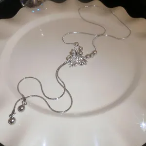Silver butterfly fringe necklace with crystal inlay and sleek snake chain on a tray