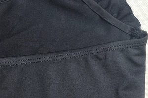 Macro shot of black dress fabric with double-stitched seams and ruffled edge detail