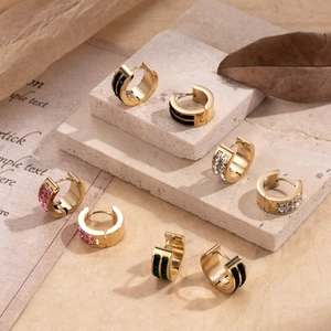 Elegant gold titanium steel hoop earrings set with colorful zircon inlay on stone surface