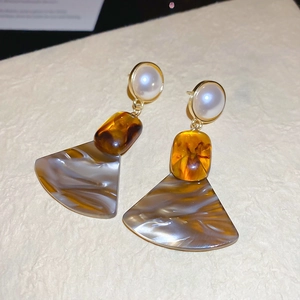 Detailed view of vintage amber resin fan earrings with white faux pearl and marble texture