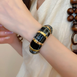 Detail of vintage acrylic marble bracelet with gold metal links on a female wrist
