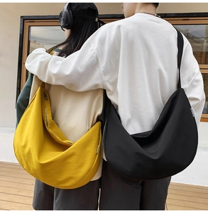 Close-up of yellow and black crescent crossbody bags showing large capacity and drape