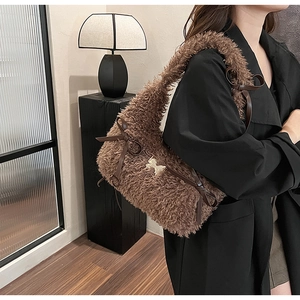 Close-up of brown plush shoulder bag featuring side leather bows and golden butterfly buckle