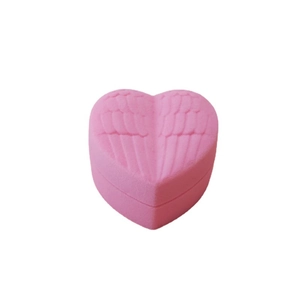 Pink heart-shaped velvet jewelry box with embossed wings and a minimalist soft finish