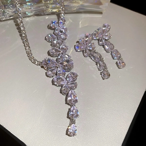 Dettaglio del set di collana e orecchini con nappine a farfalla in zirconi brillanti