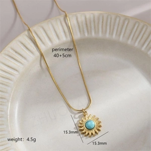 Gold titanium steel necklace featuring a turquoise sunflower pendant on a ceramic plate