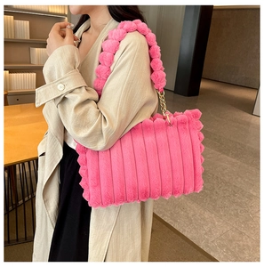 Detail of pink fuzzy tote bag showing soft striped texture and spherical chain strap