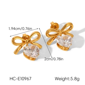 Detailed view of golden bow stud earrings with heart zirconia and measurement labels