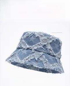 Detailed close-up of light blue denim bucket hat with frayed star pattern and raw edges