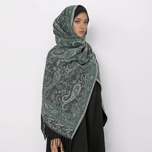 Detail view of dark green Paisley scarf featuring elegant black fringes and core-spun yarn
