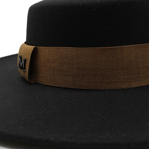 Detail of wool fedora hat showing brown ribbon band and metallic M letter accent