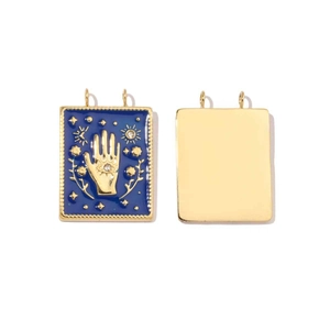 Macro view of blue enamel and gold flower butterfly charms with rectangular metal frames