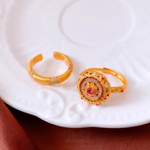 Ensemble de bagues dorées vintage avec zircon rouge et texture mate sur porcelaine