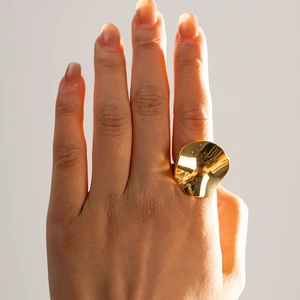 Detailed macro view of 18k gold plated stainless steel irregular disc ring on finger