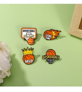 Detailed view of four basketball enamel pins featuring MVP and Game Time motifs on a desk