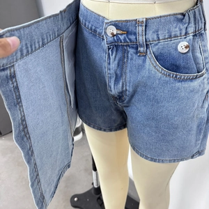 Detail showing inner shorts structure of irregular blue denim skort with button closure