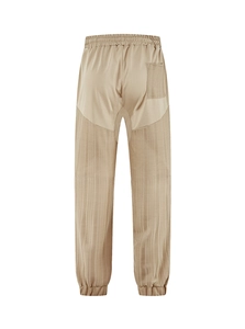 Detail of khaki jogger pants showing elastic waist, back pocket, and striped texture