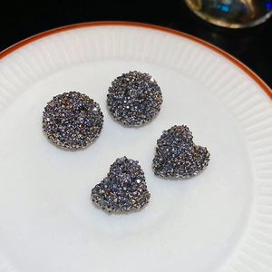 Détail macro de boucles d'oreilles cœur et rondes avec cristaux micro-pavés gris foncé