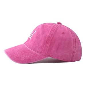 Detail of pink washed cotton baseball cap with white embroidery and vintage worn texture