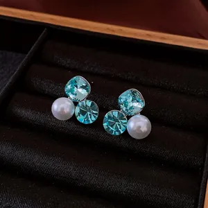 Floral silver needle earrings with blue crystal and white pearl in a black velvet box