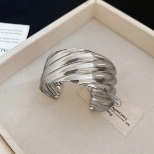 Vue macro d'un large bracelet manchette argenté avec texture ondulée irrégulière