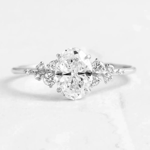 Macro shot of oval-cut zircon and small accent diamonds on a polished S925 silver ring band