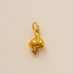 Detailed view of flower pendant in gold finish with a purple birthstone crystal