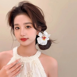 Barrette fleur blanche avec étamine jaune et perle portée par un mannequin