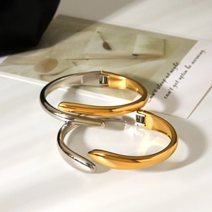 Two-tone gold and silver irregular stainless steel open bangle with a polished mirror finish