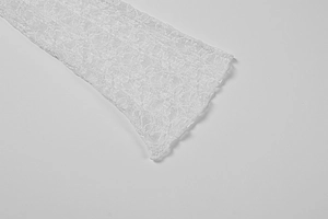 Gros plan sur les poignets en dentelle florale et les bords ondulés d'une robe blanche