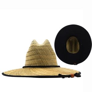 Detail of wide brim straw hat featuring black edge trim and adjustable chin strap